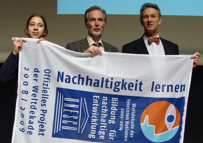 Auszeichnung fr unser Netzwerk, Mitarbeiter, Schler und Lehrer zeigen das Banner der Auszeichnung