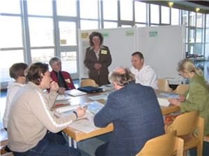 Lehrer sitzen gemeinsam am Tisch und diskutieren ber die Arbeiten