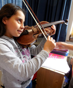 Das Foto zeigt ein Mädchen, das Geige spielt.