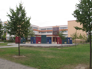 Das Foto zeigt den Gymnasialtrakt des Schulcampus - ein modernes viergeschossiges Gebäude - vom Schulhof aus gesehen.