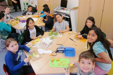 Das Foto zeigt Kinder beim gemeinsamen Mittagessen.