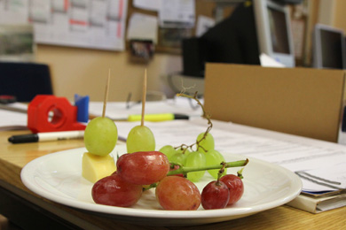 Das Foto zeigt einen Teller mit Obst und Kse auf einem Arbeitstisch im Lehrerzimmer