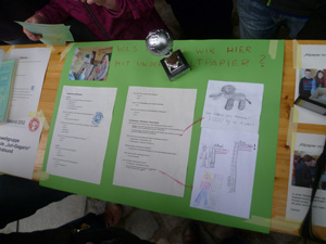Das Foto zeigt Infomaterialien zum Thema Papier sowie einen Stralsunder Umweltpokal.