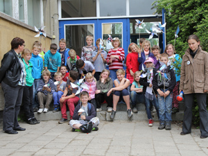 Das Foto zeigt eine Gruppe von knapp 30 Kindern, die auf der Treppe ihres Schulhauses für ein Gruppenbild posieren.