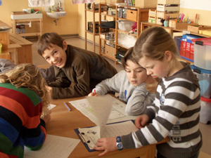Das Foto zeigt vier Kinder in einem Klassenraum, die sich Checklisten ansehen.