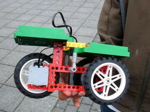 Das Foto zeigt ein solar angetriebenes Modellfahrzeug, das von der Hand eines Schülers gehalten wird.