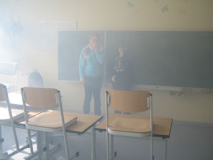 Das Foto zeigt zwei Schüler in einem stark vernebelten Klassenraum.