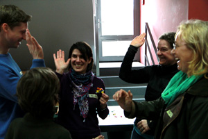 Das Foto zeigt vier Menschen, die sich freuen und mit den Händen abklatschen.