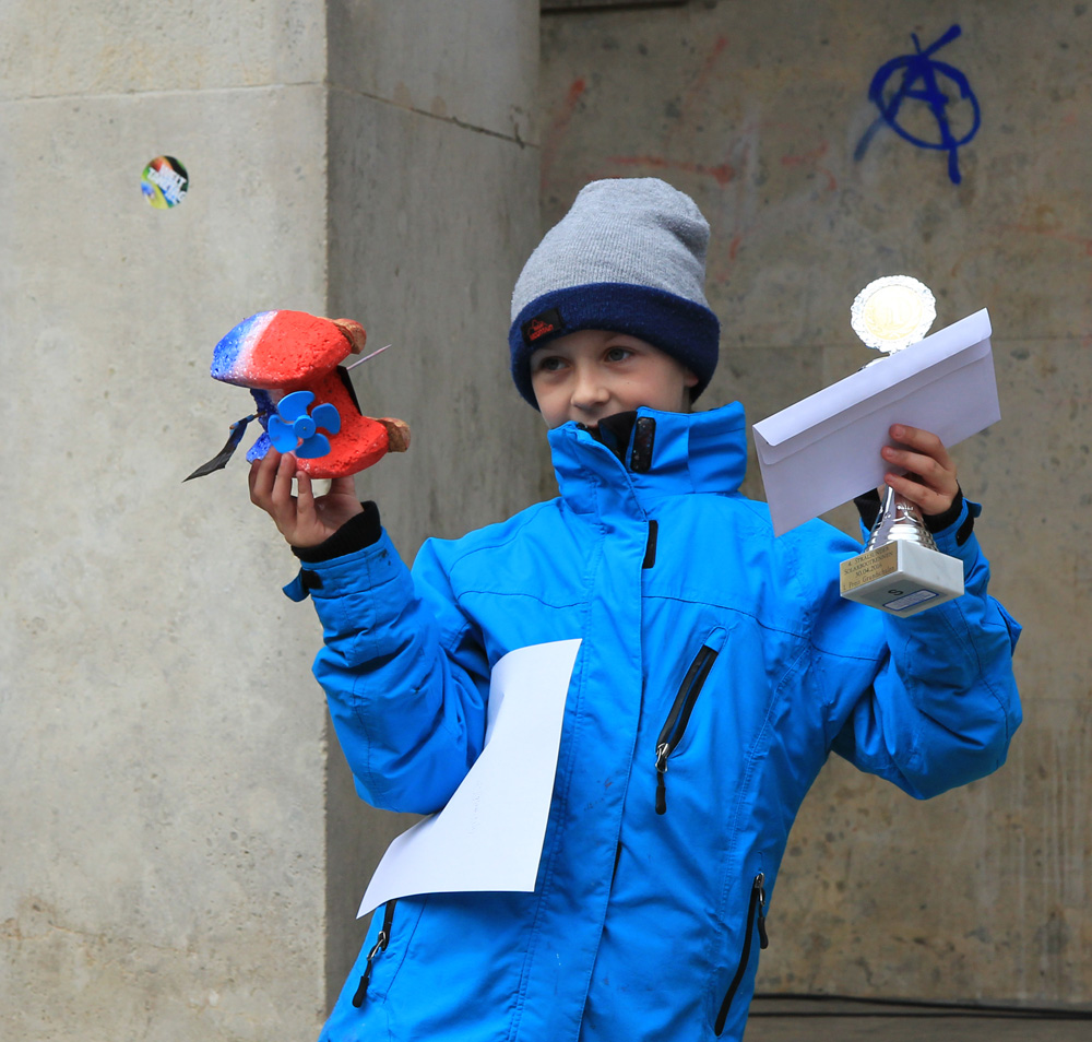 Das Foto zeigt einen Schüler mit Solarboot, Urkunde und Pokal.