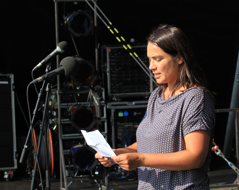Das Foto zeigt eine junge Frau beim Soundcheck auf einer Open-Air-Bühne.