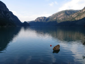 Das Foto zeigt einen See in Norwegen mit einem kleinen Boot.
